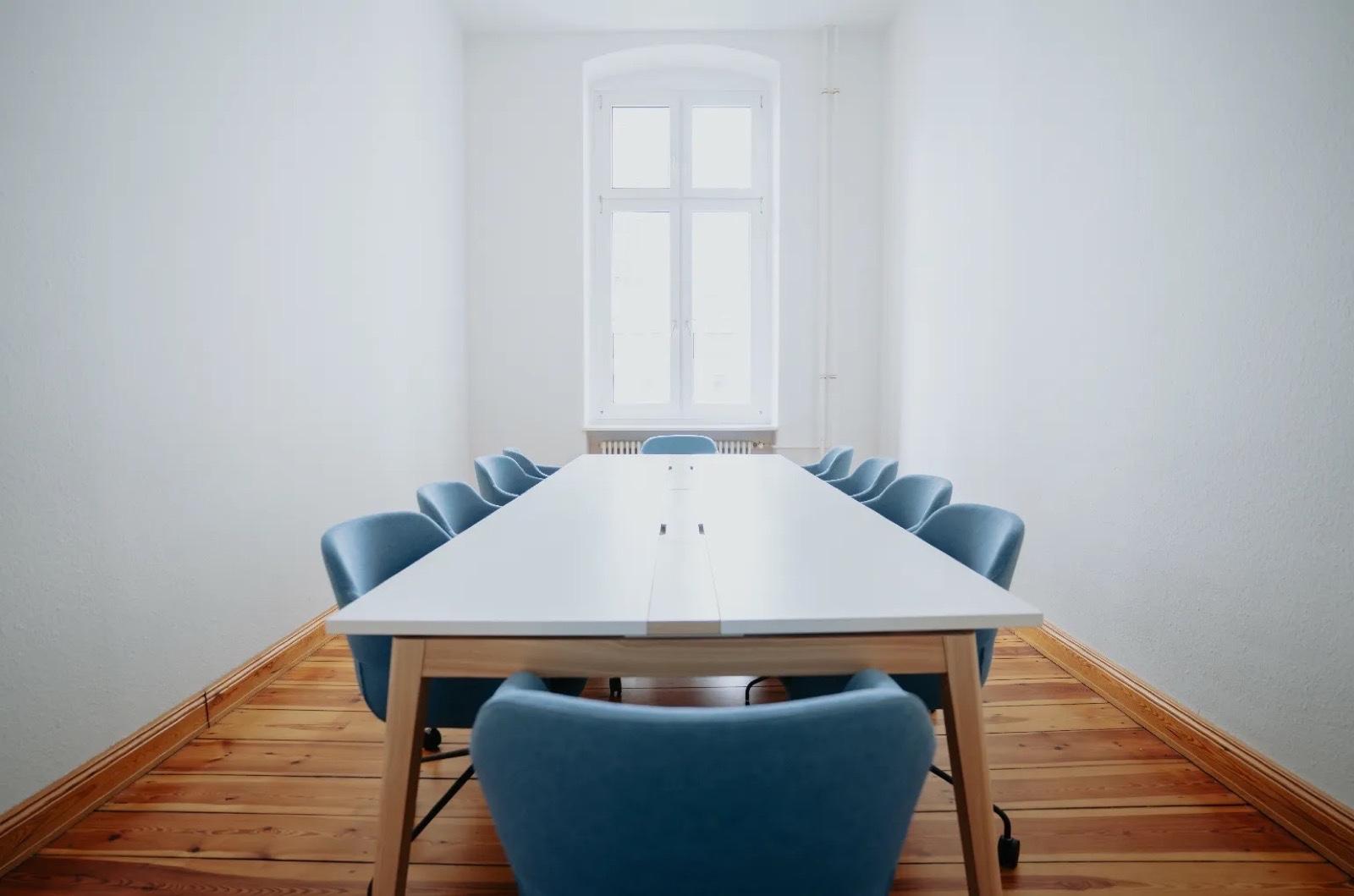 Konferenzraum mit refurbished blauen Stühlen und weißem Tisch bei bcause in Berlin