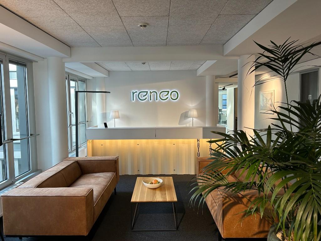 Empfangsbereich der Reneo Group mit reneo-Logo an der Wand.