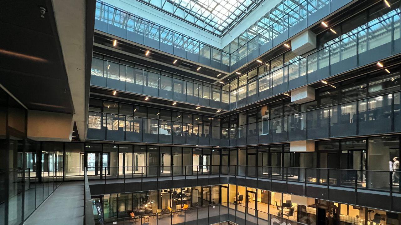 Atrium des The Delta Campus in Berlin mit Glasgalerien über mehrere Etagen und Oberlicht